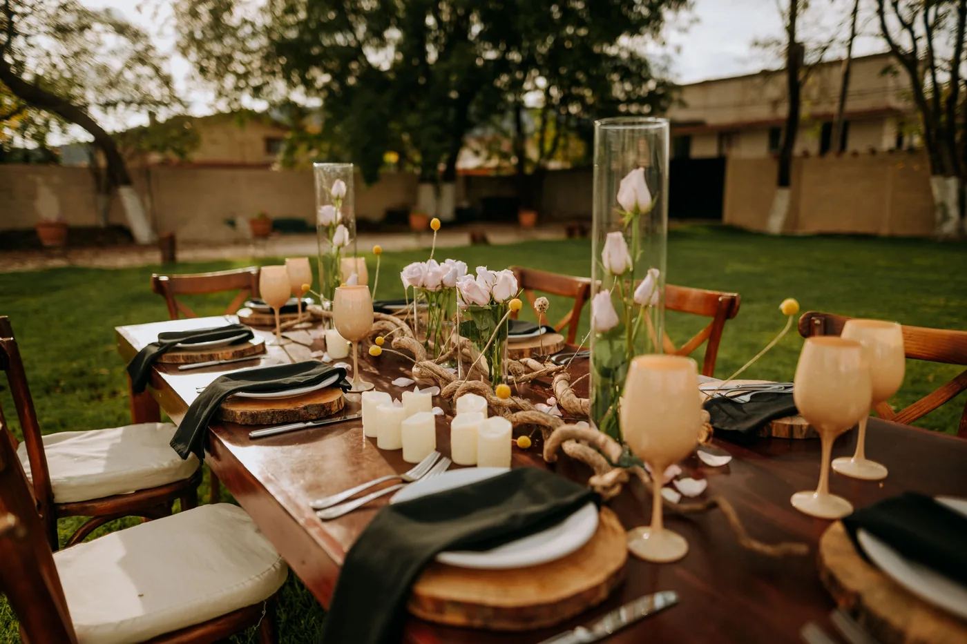 Detalle de mesa montada con flores, velas y cristalería para una comida privada