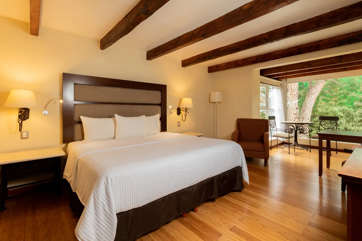 Junior Suite con cama king y sala de estar junto al ventanal