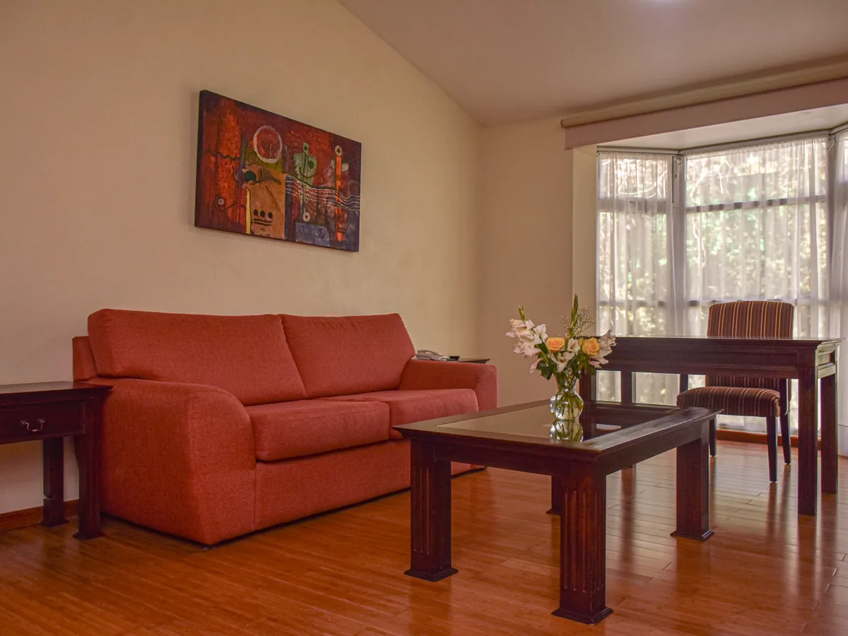 Ver: Sala de la Master Suite con sofá, mesa de comedor y ventanal al jardín